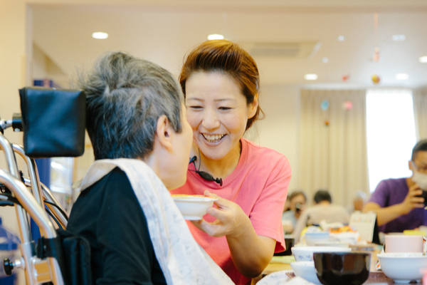 スタッフが明るく利用者に接するクレアの様子